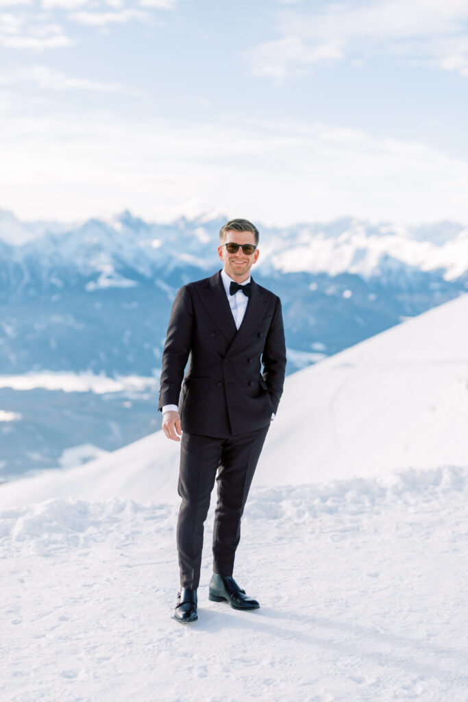 groom in the snowy mountains after his wedding
